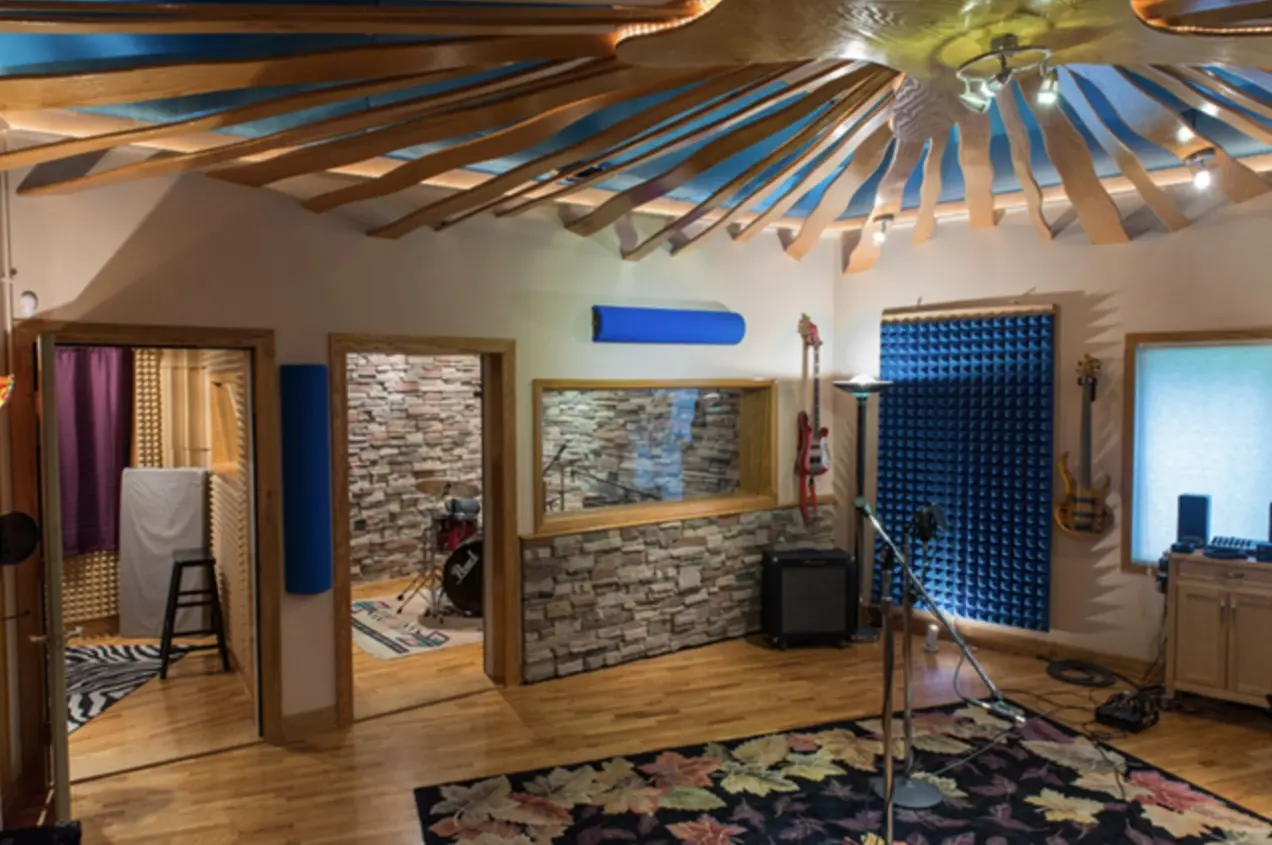 The Markosa Studios live room, with its sunburst wood ceiling, stone wall and patterned rug